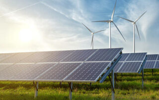 Solar Panels And Wind Generators Under Blue Sky On Sunset