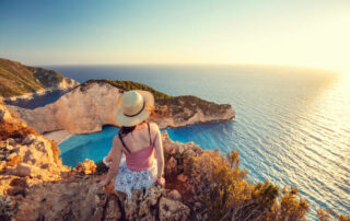 Woman Tourist In Zakynthos, Greece Admiring The Navagio Shipwreck Beach